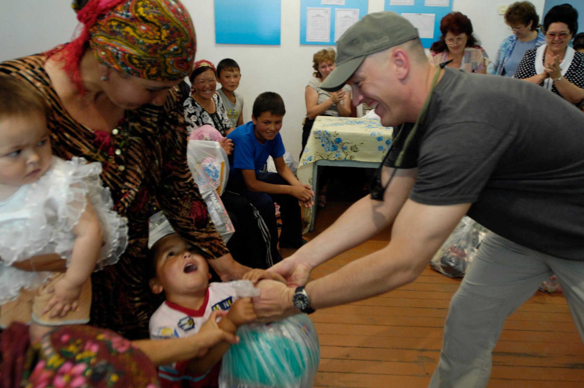 Airmen of the 376th Expeditionary Security Forces Squadron, Manas Air Base, Kyrgyz Republic, hand out gift bags to some of the less fortunate members of Oktyabrskoye village in recognition of International Protection Day, which is June 1. The gift bags included hygiene products, T-shirts,  towels, candy, coloring books, toys, and other much needed supplies.  The items were purchased with money allocated from the private organizations on base and with donations from home units of the security forces members. (U.S. Air Force Photo by Staff Sgt. Tabitha Kuykendall) (RELEASED) 