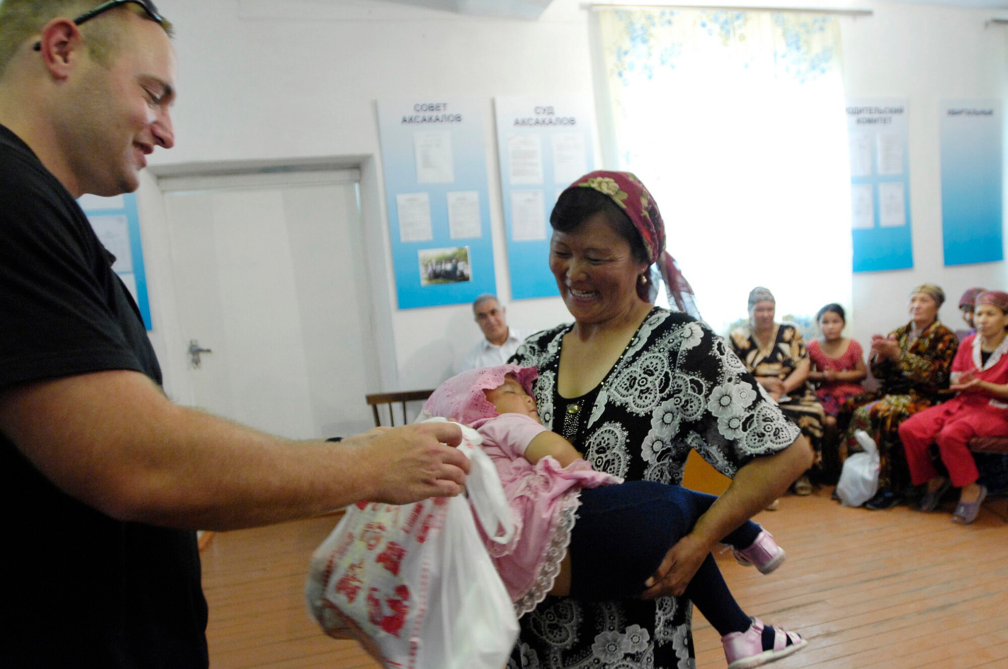 Staff Sgt. Ryan McNamara, 376th Expeditionary Security Forces Squadron, Manas Air Base, Kyrgyz Republic, hands out gift bags to some of the less fortunate members of Oktyabrskoye village in recognition of International Protection Day, which is June 1. The gift bags included hygiene products, T-shirts,  towels, candy, coloring books, toys, and other much needed supplies.  The items were purchased with money allocated from the private organizations on base and with donations from home units of the security forces members. (U.S. Air Force Photo by Staff Sgt. Tabitha Kuykendall) (RELEASED) 