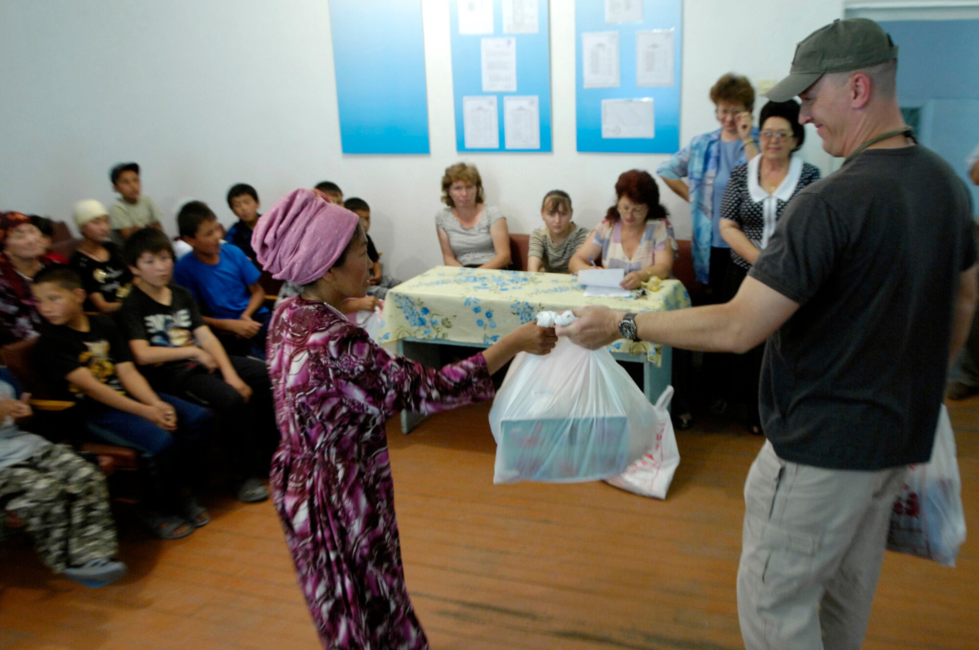 Airmen of the 376th Expeditionary Security Forces Squadron, Manas Air Base, Kyrgyz Republic, hand out gift bags to some of the less fortunate members of Oktyabrskoye village in recognition of International Protection Day, which is June 1. The gift bags included hygiene products, T-shirts,  towels, candy, coloring books, toys, and other much needed supplies.  The items were purchased with money allocated from the private organizations on base and with donations from home units of the security forces members. (U.S. Air Force Photo by Staff Sgt. Tabitha Kuykendall) (RELEASED) 