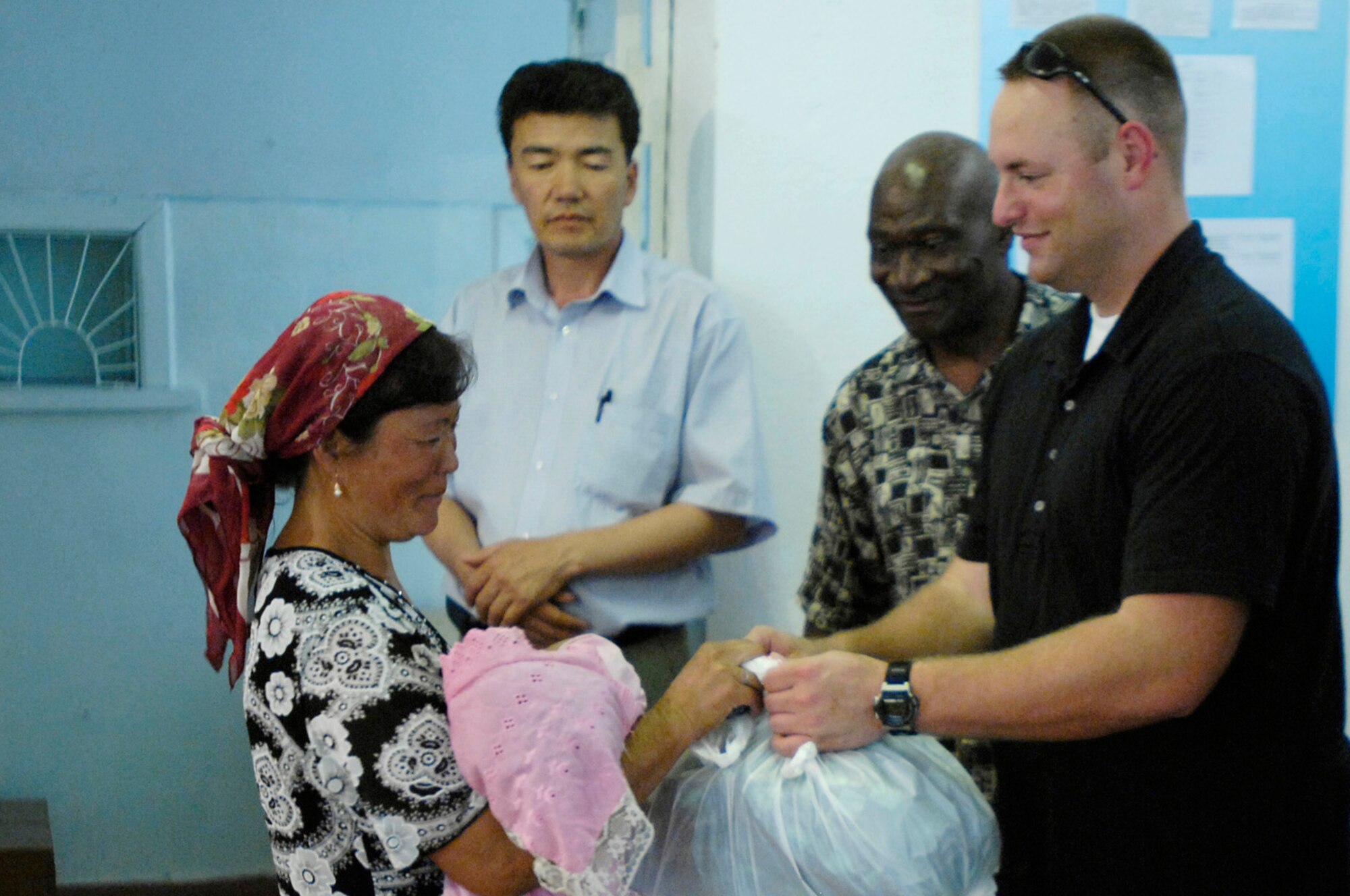 Staff Sgt. Ryan McNamara, 376th Expeditionary Security Forces Squadron, Manas Air Base, Kyrgyz Republic, hands out gift bags to some of the less fortunate members of Oktyabrskoye village in recognition of International Protection Day, which is June 1. The gift bags included hygiene products, T-shirts,  towels, candy, coloring books, toys, and other much needed supplies. The items were purchased with money allocated from the private organizations on base and with donations from home units of the security forces members. (U.S. Air Force Photo by Staff Sgt. Tabitha Kuykendall) (RELEASED) 