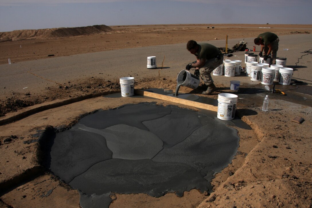 Cpl. Benjamin Mizell (right), a combat engineer with Marine Wing Support Squadron 273 and Pfc. Shaun Chapell, combat engineer from MWSS-273, work together to fill a large hole on a taxiway at Sahl Sinjar Air Field in Nineweh province, Iraq Nov. 1, 2008.