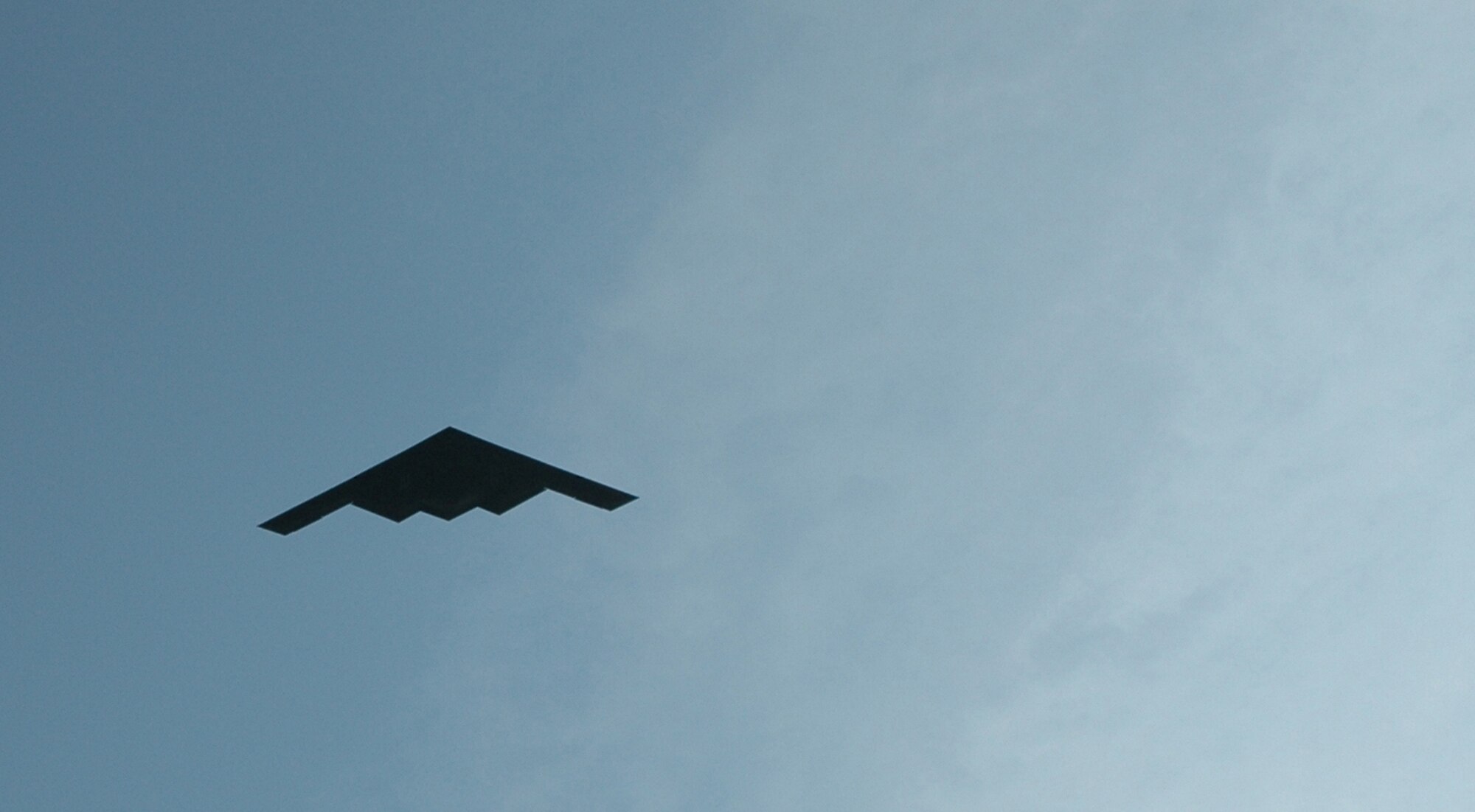 A B-2 Bomber flies over the ribbon cutting ceremony at Whiteman Air Force Base Oct. 4.  October was the first official drill for traditional guardsmen from the 131st Fighter Wing transitioning to the 131st Bomb Wing. (Photo by Master Sgt. Mary-Dale Amison)