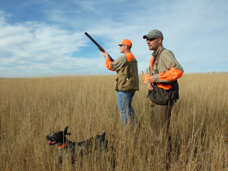 An airman from the 119th Wing prepares to take aim at a flushing rooster pheasant, as Benjamin Sand and his German Wirehaired Pointer, Amber, assist him in his pursuit of upland game birds on the grassy prairies of southwestern North Dakota.


