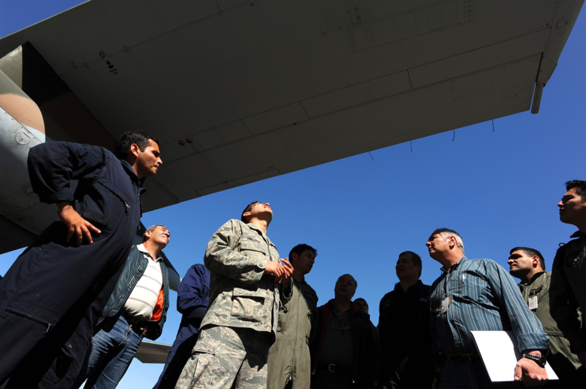Staff Sgt. David Hinojosa (center) checks for structural damage to Argentinean air force C-130 Hercules' wing during an aircraft maintenance evaluation at Palomar Air Base, Buenos Aires, Argentina during Operation Southern Partner Oct. 30. Operation Southern Partner is an in-depth, two-week subject matter exchange emphasizing partnership, cooperation and sharing of information with partner nation Air Forces in Latin America. Staff Sgt. Hinojosa is an aircraft structural maintenance instructor for the Inter-American Air Force Academy at Lackland Air Force Base, Texas.(DMA-SA photo/Staff Sgt. Bennie J. Davis III) 