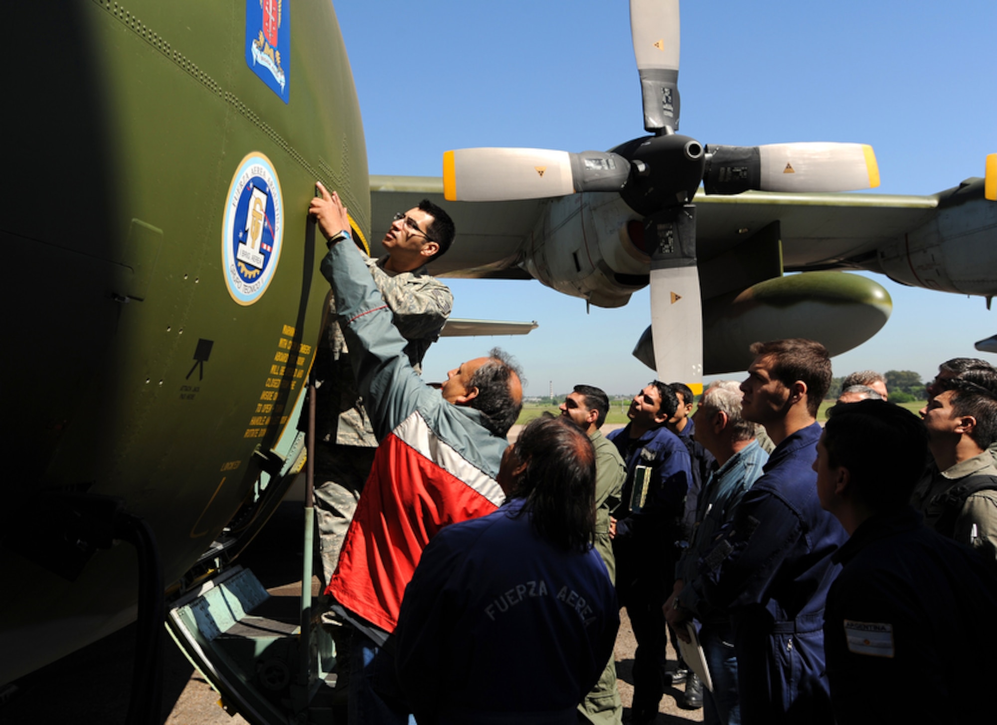 U.S. Air Force Staff Sgt. David Hinojosa points out properly conducted structural repairs over the door frame on a C-130 Hercules during an evaluation of C-130 aircraft repairs at Palomar Air Base, Buenos Aires, Argentina. Sergeant Hinojosa is participating in Operation Southern Partner -- an in-depth, two-week subject matter exchange emphasizing partnership, cooperation and sharing of information with partner nation Air Forces in Latin America. (Air Force photo/Staff Sgt. Bennie J. Davis III) 