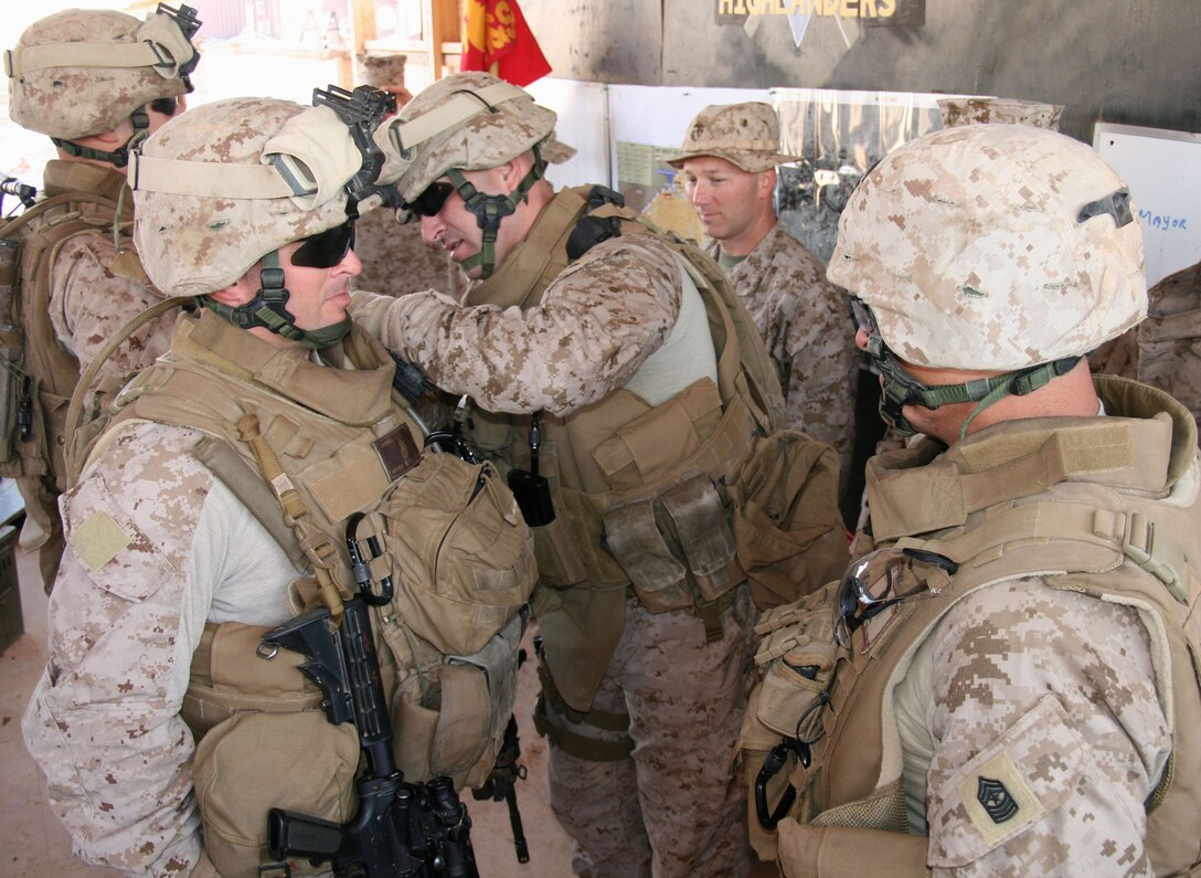 Lt. Col Geoff Rollins (center) pins the new rank insignia of master sergeant on Thomas Carroll during a promotion ceremony here Nov. 1, 2008.  Rollins was the 2nd Battalion, 25th Marine Regiment commanding officer from 2008-2009.  Marine Corps Reserve infantry battalions are usually commanded by a reserve lieutenant colonel who deploys with the unit when they mobilize.