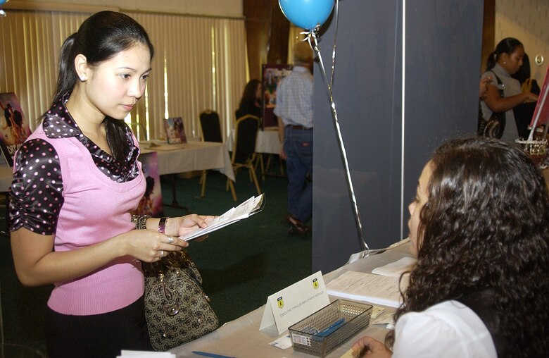 Joni Diaz, wife of Muriel Diaz, 36th Force Support Squadron, receives information regarding a future employment opportunity at the Executive Typing and Employment Service booth during the Andersen Job Fair held Oct. 29 at the Palm Tree Golf Course Conference Center. (U.S. Air Force photo by Airman 1st Class Carissa Wolff)                         
