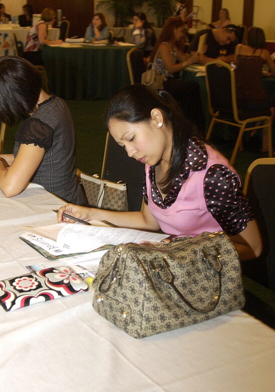 Joni Diaz, wife of Muriel Diaz, 36th Force Support Squadron, takes a moment to complete job applications she acquired during the Andersen Job Fair held Oct. 29 at the Palm Tree Golf Course Conference Center. (U.S. Air Force photo by Airman 1st Class Carissa Wolff)                              
