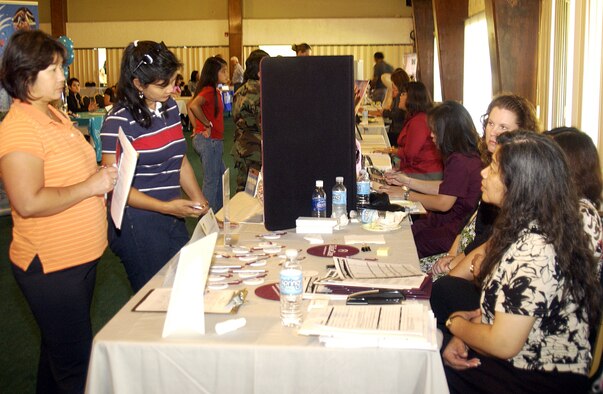 Military dependants Maria Cruz, wife of Maj. Andrew Cruz, 36th Medical Group and Ruby Acasio, wife of Master Sgt. Danny Acasio, 36th MDG, receive information about possible job opportunities at the FHP booth at Andersen's Job Fair held Oct. 29 at the Palm Tree Golf Course Conference Center. (U.S. Air Force photo by Airman 1st Class Carissa Wolff)                            