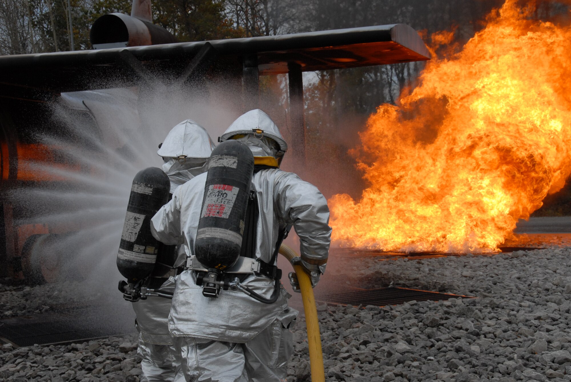 Two firefighters with the 127th Wing, Selfridge Air National Guard Base, Mich., combat a controlled fire to meet their annual training requirements at the Combat Readiness Training Center, Alpena, Mich., in October.  (U.S. Air Force Photos by SrA Anna-Marie Wyant) (Released)
