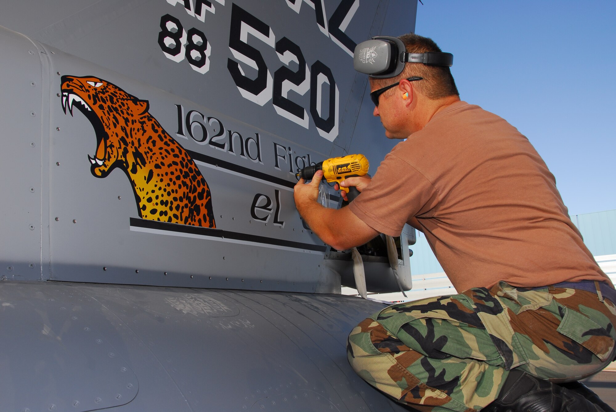 Tech. Sgt. Rick Bain attaches a freshly-painted tailflash to the 162nd Fighter Wing commander's F-16 on the flightline here Nov. 1. The panel features the unit mascot "El Tigre," a jaguar native to the Sonoran desert. The roaring "tigre" was painted by Staff Sgt. Aaron Roop, a structural maintainer, and designed by Senior Airman Jonathan Rojas, a graphic artist assigned to the wing public affairs office. (Arizona Air National Guard photo by Senior Airman Sarah Elliott)