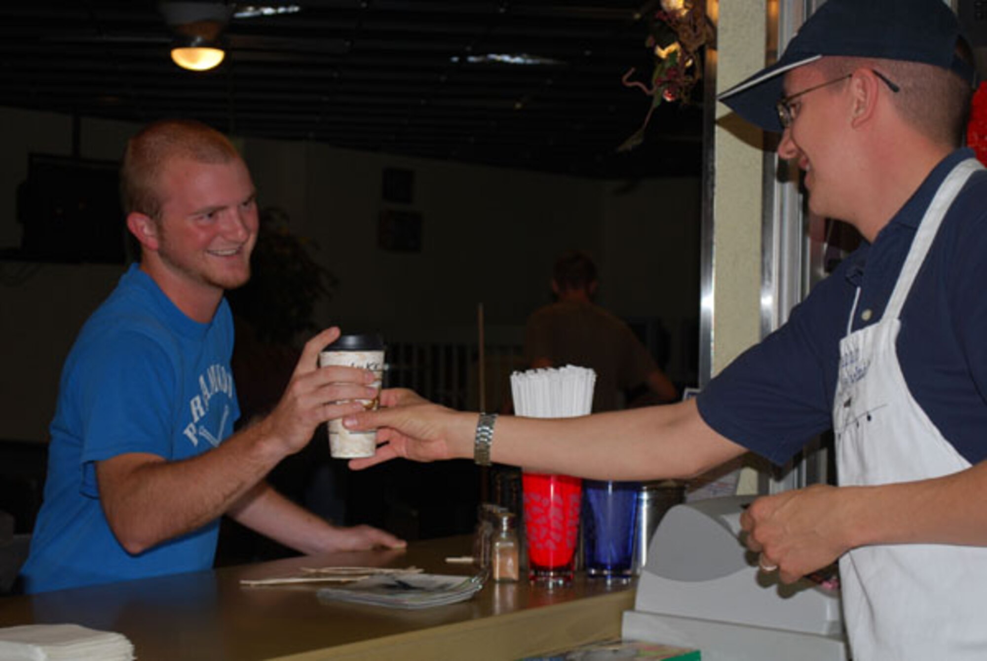 Airman First Class Luke Duginske, 960th AACS, grabs a fresh cup of java from Kelly Stahl, 507th ARW chaplain. Stahl volunteers his time at the Latte Lounge.