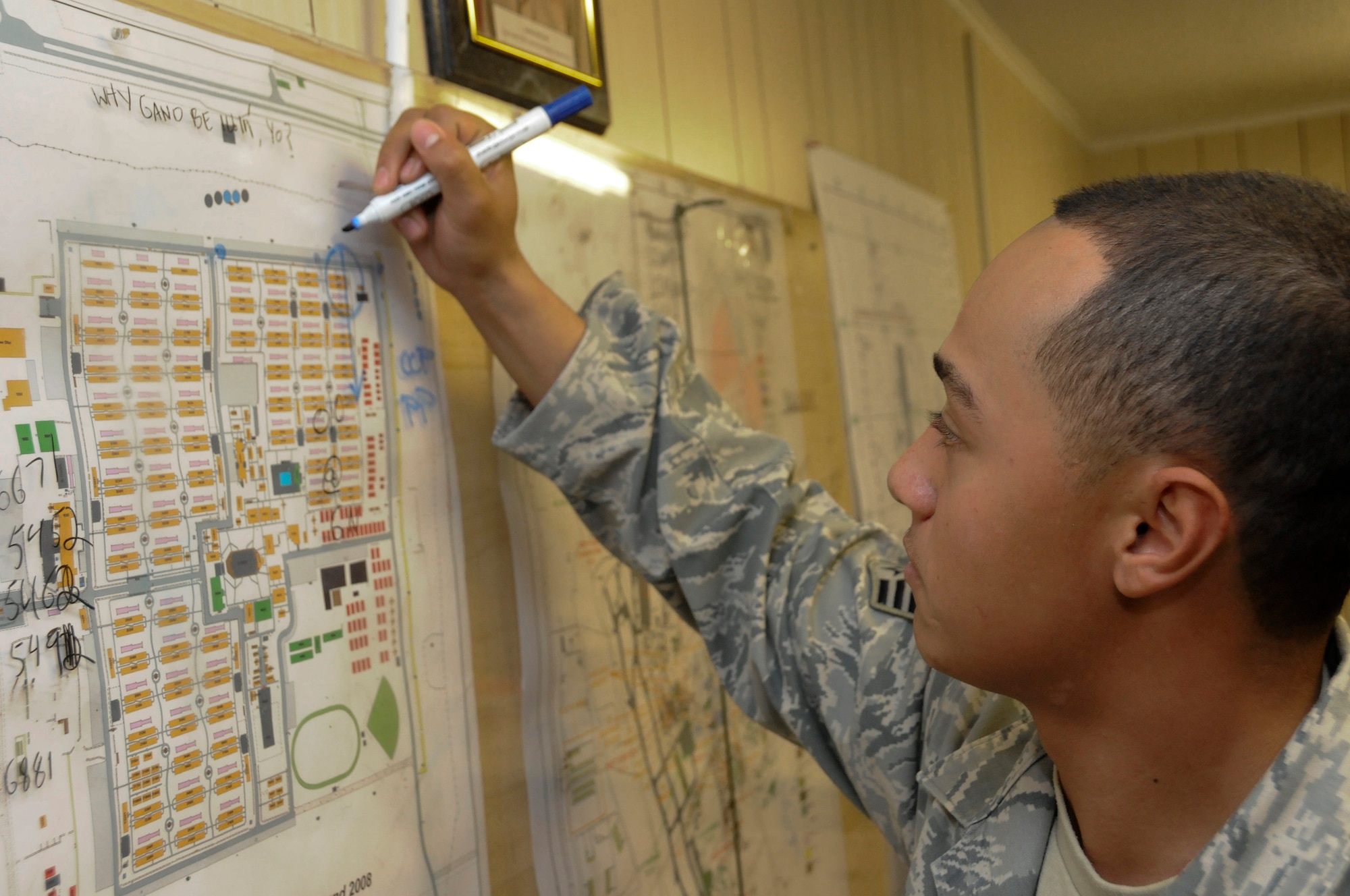 Staff Sgt. Eric Proctor, 379th Expeditionary Security Forces Squadron, manually plots a cordon on a base map for a simulated unexploded ordinance discovery, October 31, at an undisclosed air base in Southwest Asia.  The entry control points are marked varying by the size and type of the ordinance.  The ability to manually set up a controlled area must be maintained in case of power or computer failure.  Sergeant Proctor is a native of Washington D.C., and is deployed from Schriever Air Force Base, Colo., in support of Operations Iraqi and Enduring Freedom and Joint Task Force-Horn of Africa.  (U.S. Air Force photo by Tech. Sgt. Michael Boquette/Released)