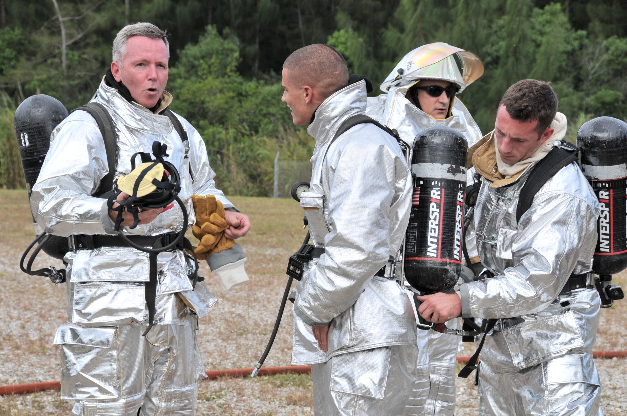 Col. William “Blaze” Binger, 482nd Fighter Wing commander, left, takes a deep breath as fire fighters from Homestead Air Reserve Base prepare to remove their personal protective equipment after completing a live fire training exercise Nov. 1.  Reservists from the Homestead ARB Fire Department invited the commander to participate in the exercise so he may better understand the type of training required and equipment used for real aircraft emergencies. (U.S. Air Force photo/Tim Norton)