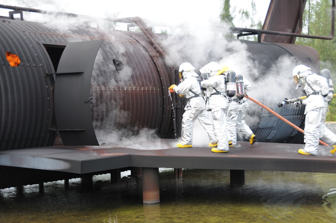 Col. William “Blaze” Binger, 482nd Fighter Wing commander, left, and Reservists from the Homestead Air Reserve Base Fire Department, prepare to enter a burning, simulated KC-10 aircraft during a live fire training exercise Nov. 1.  The fire fighters invited the commander to participate in the exercise so he may better understand the type of training required and equipment used for real aircraft emergencies. (U.S. Air Force photo/Tim Norton)