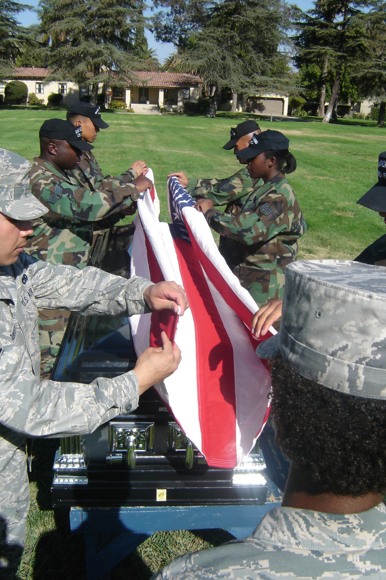A1C Zakia Webster, 163 RW, gives commands as pallbearers prepare the flag for the tabletop position during a mock honors funeral. Pallbearers are: (left side, near to far) SrA Oscar Cortes, SrA Cory Montgomery and SrA Terrence Mananes. (right side, near to far) Staff Sgt. Dana Milkes, Staff Sgt. Hilda Agyemang and Tech. Sgt. Jonathan Gaygay. (U.S. Air Force photo by Will Alexander)