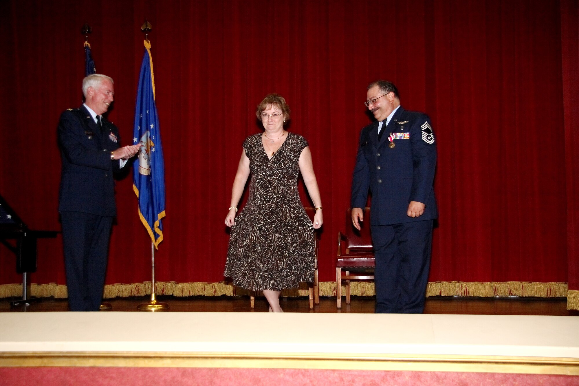 Christine Ellis makes a curtsy before she is recognized for her contributions to her husband’s military career during the retirement ceremony on Oct. 19 at the Cultural Resource Center. (U.S. Air Force photo)