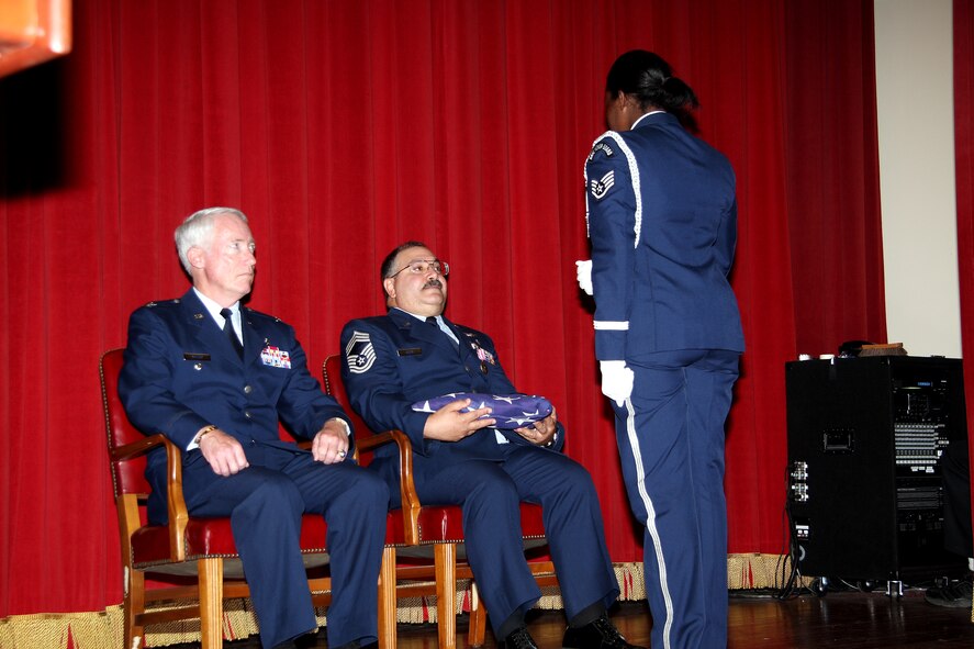 A member of the Base Honor Guard presents Chief Ellis with an American flag in recognition of his service to the Air Force and Air Force Reserve. (U.S. Air Force photo)