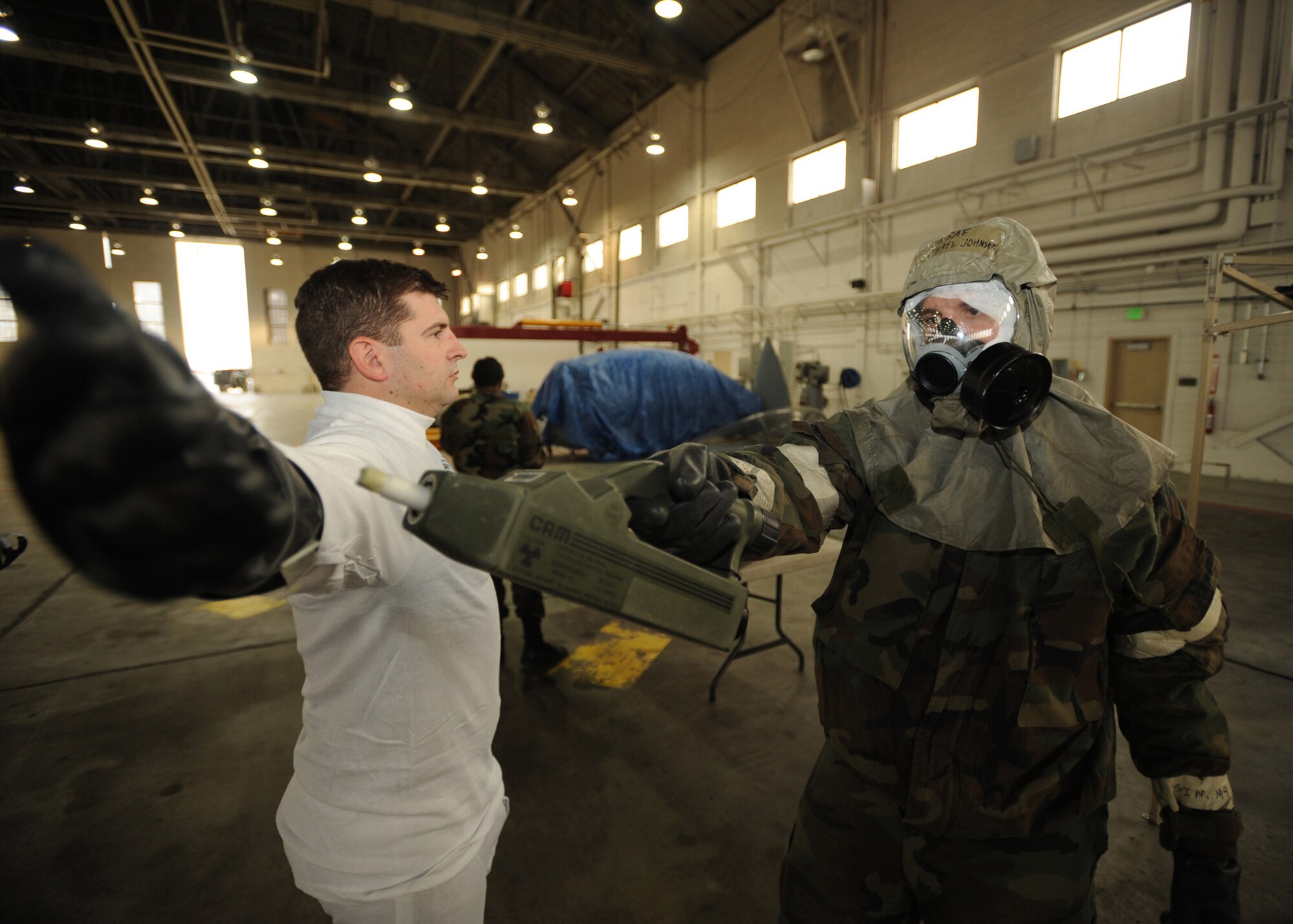ELMENDORF AIR FORCE BASE, Alaska -- Airman 1st Class Michael Johnson, 3rd Civil Engineer Squadron, checks Capt. Ryan Eads, 962nd Airborne Air Control Squadron, for chemical contamination during the Polar Force 09-1 exercise Oct. 30. The aircrew decontamination scenario was held at Hangar 5. This was one of many different scenarios presented to personnel during the three-day exercise. (U.S. Air Force photo/Senior Airman Matthew Owens)