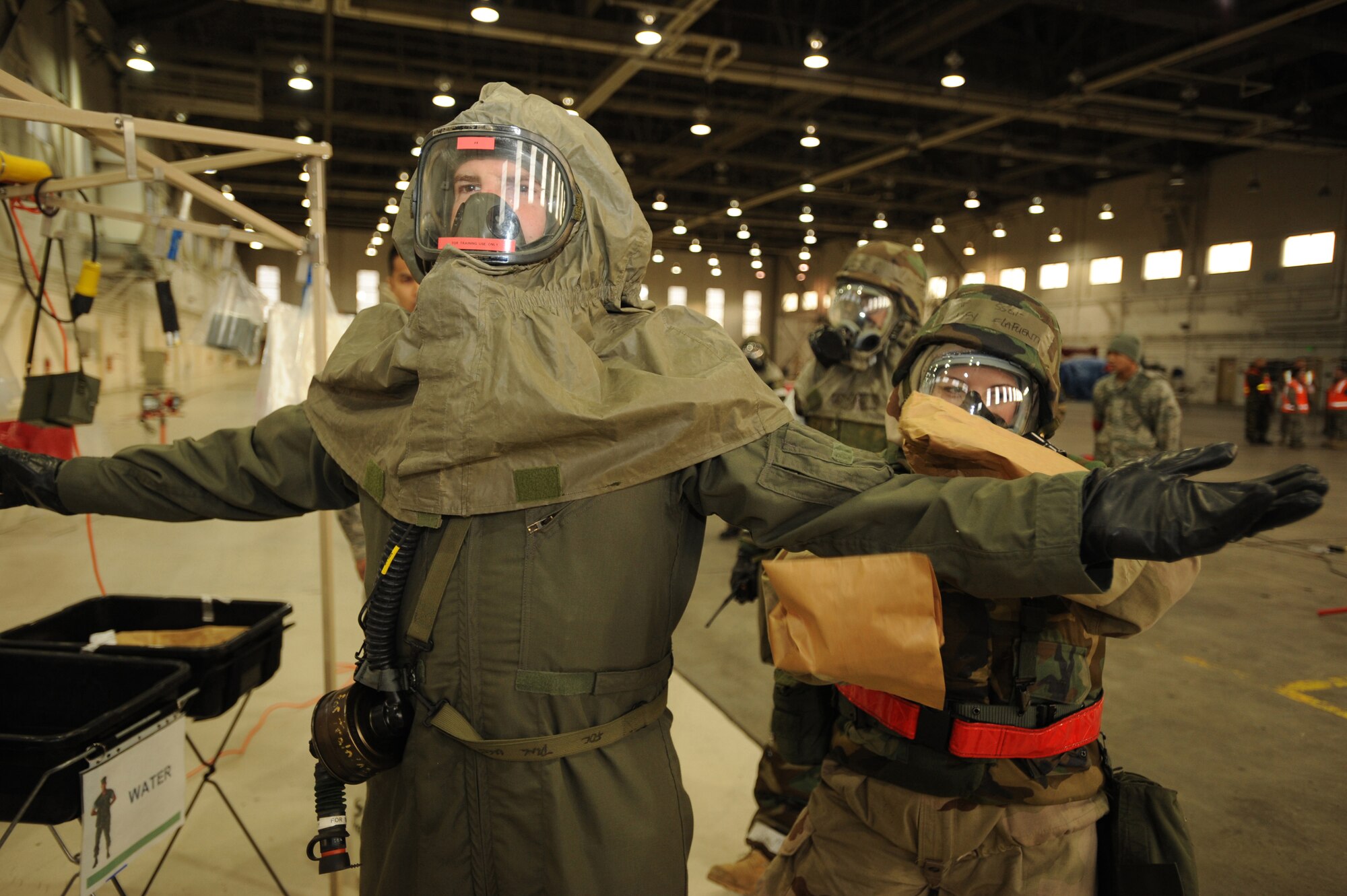 ELMENDORF AIR FORCE BASE, Alaska -- Staff Sgt Chelsey Delafuente, 3rd Civil Engineer Squadron, decontaminates the flight suit of Capt. Ryan Eads, 962nd Airborne Air Control Squadron, during the Polar Force 09-1 exercise Oct. 30. This aircrew decontamination scenario took place in Hangar 5 during the three-day exercise. (U.S. Air Force photo/Senior Airman Matthew Owens)