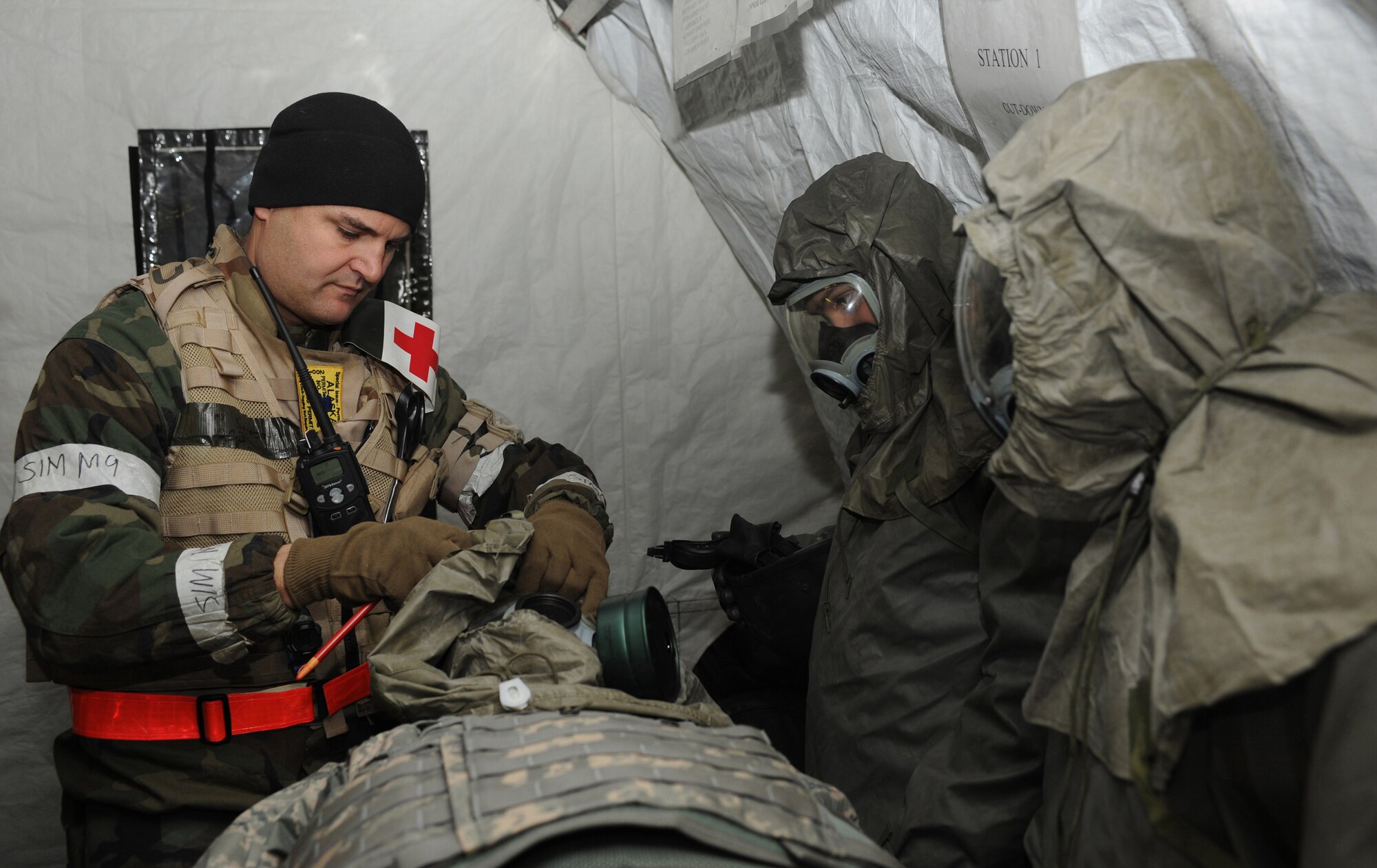 ELMENDORF AIR FORCE BASE, Alaska -- Capt. (Dr.) Dennis Spencer, 3rd Medical Group, acts as an exercise evaluator at Camp Madbull during the Polar Force 09-1 exercise Oct. 29. Captain Spencer demonstrates to on-lookers how to properly remove a gas mask from an injured patient during the medical decontamination scenario. (U.S. Air Force photo/Senior Airman Matthew Owens)