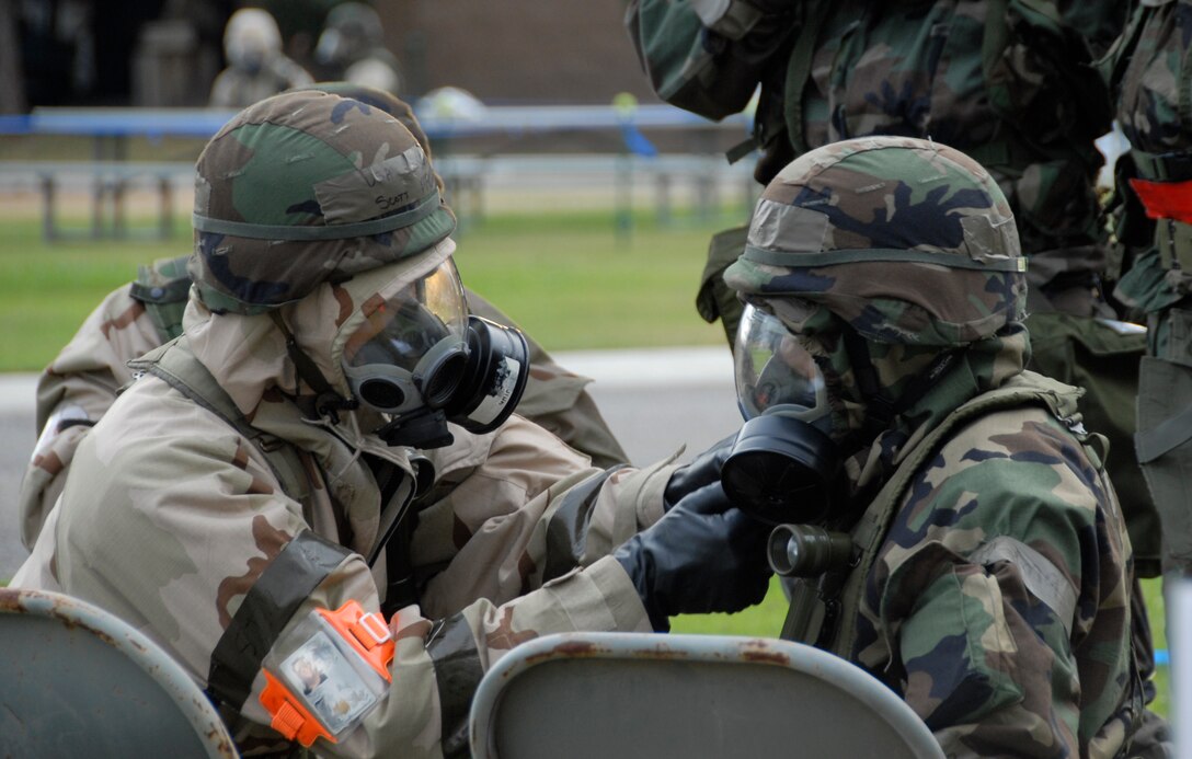 FRESNO ANGB, Calif. -- Airmen from the 144th Fighter Wing respond to a simulated terrorist attack during the unit's Phase II Operational Readiness Exercise Nov. 1, 2008. Personnel rapidly evacuated a building under attack taking shelter in a nearby bunker and donning chemical protective suits. Members are shown here using the buddy system to check each other's equipment. (U.S. Air Force photo by 1st Lt. Theresa M. Chrystal)