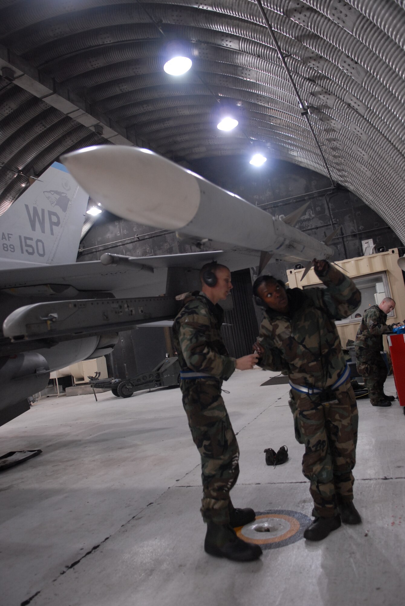 Senior Airman Brianne Brown and, Airman 1st Class Joshua Hnatiuk, 8th Aircraft Maintenance Squadron, inspect a weapon after loading it on a F-16 Fighting Falcon during a peninsula-wide Operational Readiness Exercise Beverly Bulldog 08-04 at Kunsan Air Base, Republic Of Korea, Nov. 4, 2008. Airmen participating in the PENORE will be tested on their wartime capabilities and response actions in order to complete the Wolf Pack mission. (U.S. Air Force photo by: Senior Airman Angela Ruiz/RELEASED by MSgt John Foster)