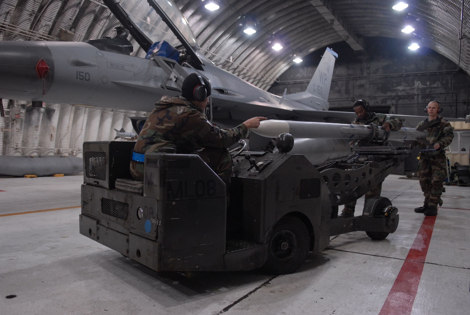 Airman 1st Class Corey Radel, Senior Airman Brianne Brown and Airman 1st Class Joshua Hnatiuk, 8th Aircraft Maintenance Squadron, load a weapon onto the F-16 Fighting Falcon during a peninsula-wide Operational Readiness Exercise Beverly Bulldog 08-04 at Kunsan Air Base, Republic Of Korea, Nov. 4, 2008. Airmen participating in the PENORE will be tested on their wartime capabilities and response actions in order to complete the Wolf Pack mission. (U.S. Air Force photo by: Senior Airman Angela Ruiz/ RELEASED by MSgt John Foster)