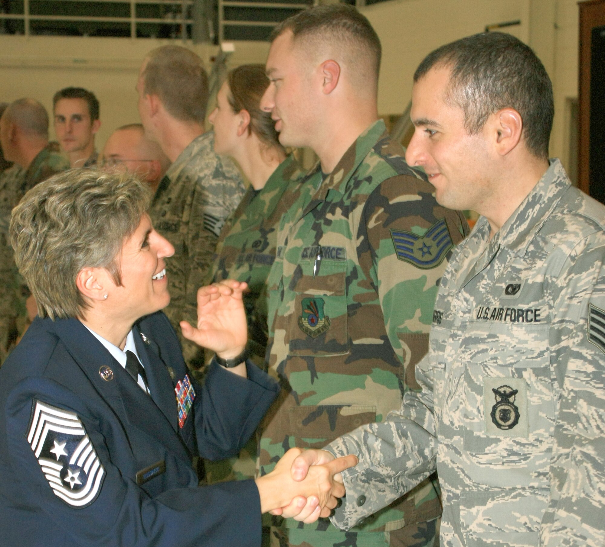 GRISSOM AIR RESERVE BASE, Ind., -- Chief Master Sgt. Peri Rogowski, 434th ARW command chief, congratulates Staff Sgt. Alexander Harris, 434th Security Forces Squadron, on his recent promotion. The 434th ARW unveiled a new format for the unit's quarterly promotion ceremony, holding the event in one of the base's aircraft hangars. (U.S. Air Force photo/Tech. Sgt. Pat Kuminecz)