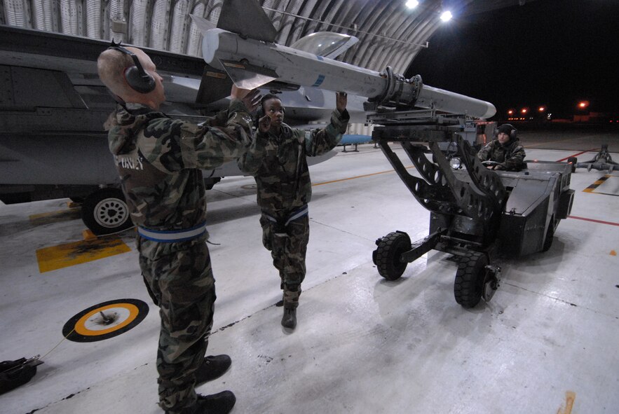 Airman 1st Class Joshua Hnatiuk, Senior Airman Brianne Brown and Airman 1st Class Corey Radel, 8th Aircraft Maintenance Squadron, load an Aim 120 missile on an F-16 during exercise Beverly Bulldog 08-04 at Kunsan Air Base, Republic of Korea, November 4, 2008. Kunsan is participating in the Peninsula-Wide Operational Readiness Exercise as a test of its wartime capabilities and response actions. (U.S. Air Force Photo by SrA Gustavo Gonzalez)