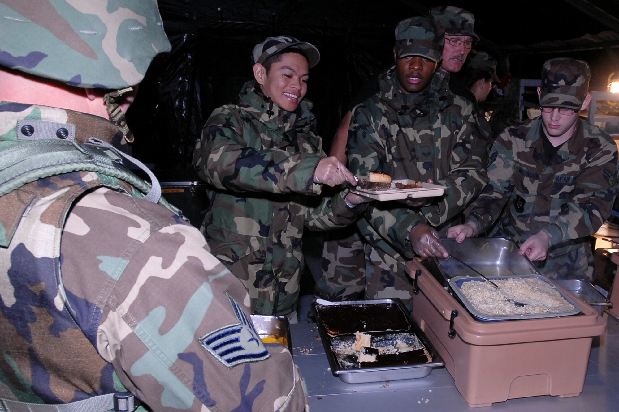GRISSOM AIR RESERVE BASE, Ind., -- Members of the 434th Services Flight serve a hot meal to members of the 434th Civil Engineer Squadron during  a bivouac held during a unit training assembly. Services teamed with the civil engineers to train in field conditions. (U.S. Air Force photo/Senior Airman Carl Berry)