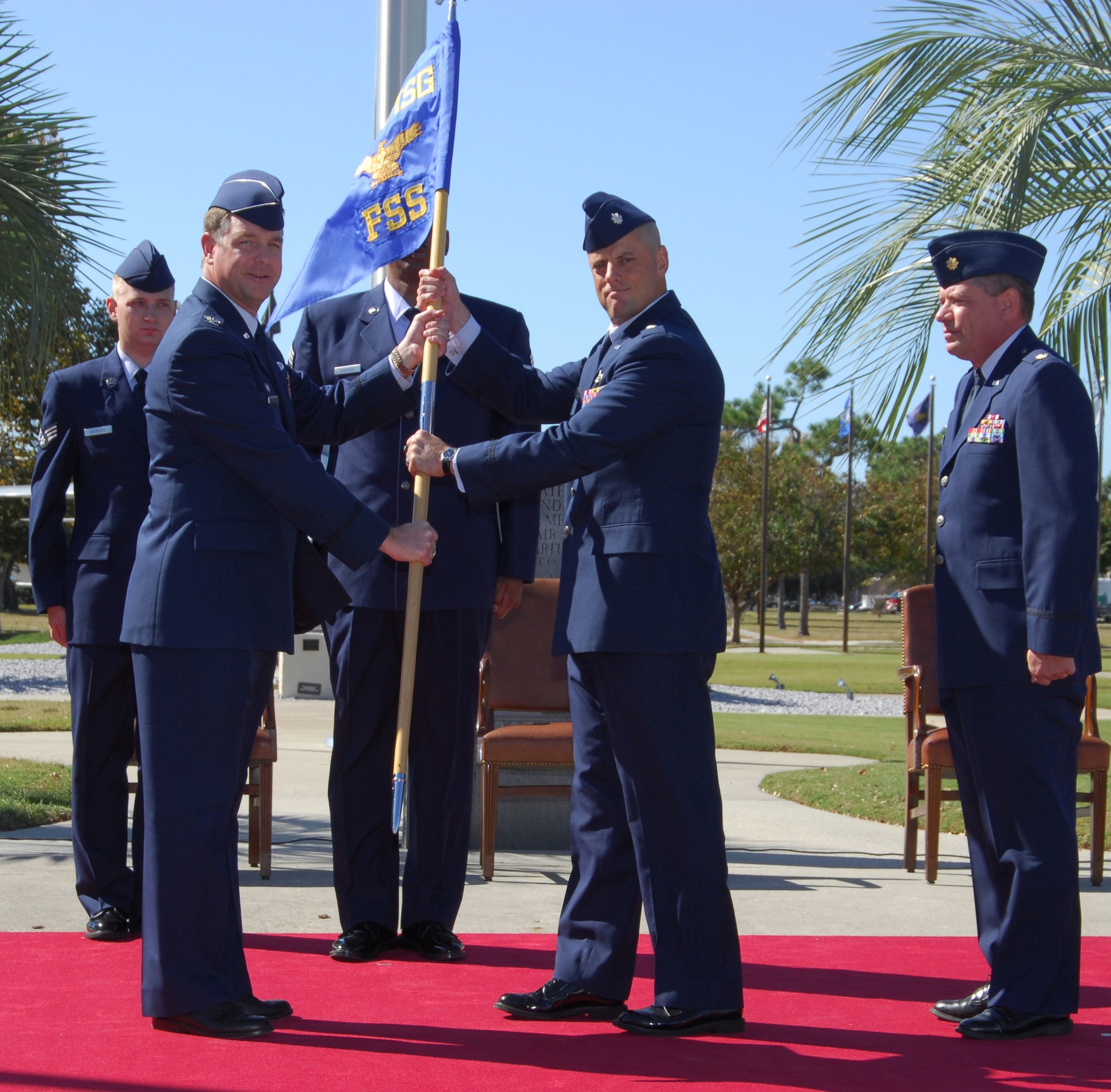 Col. David Zeh, 325th Mission Support Group commander, passes the 325th Force Support Squadron guidon to Lt. Col. Michael Lamb, 325th Services Squadron commander, Monday completing the activiation of the 325th Force Support Squadron.  (Photo taken by Lisa Norman)