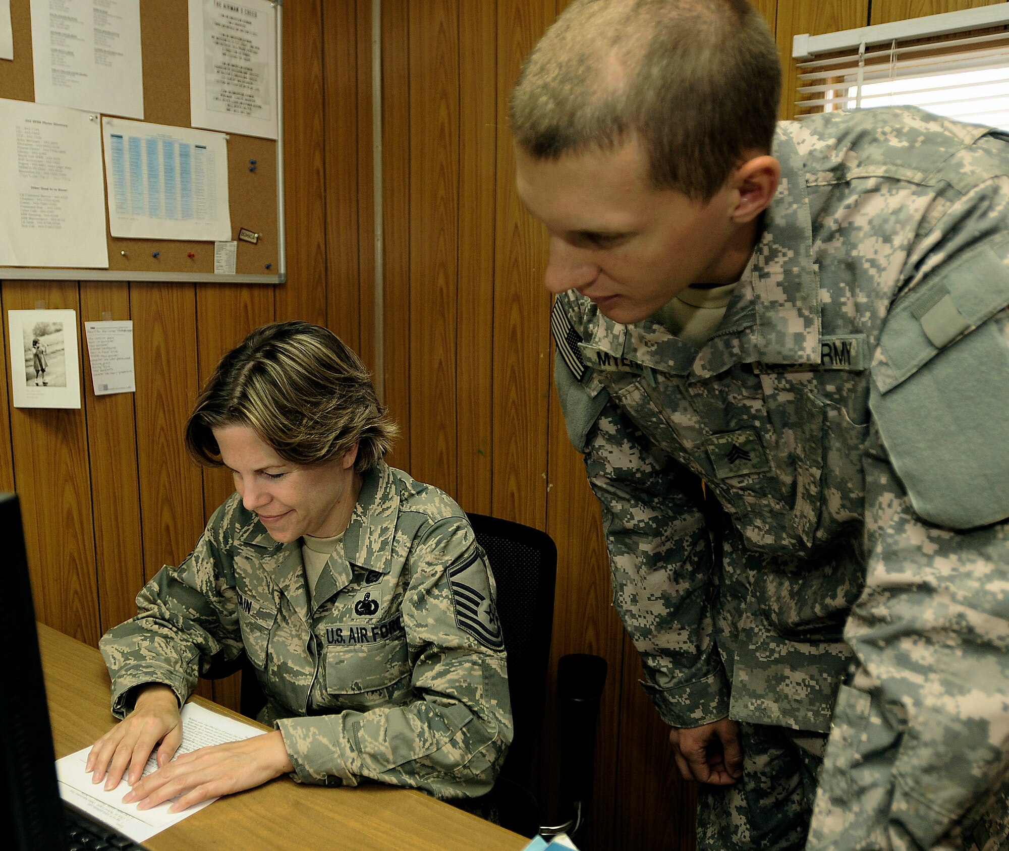 Master Sgt. Laura Cain proctors a college exam for Army Sgt. John Meyers in the Red Tail Education Center at Joint Base Balad, Iraq. A joint-service initiative, called Base Operating Support-Integration, is scheduled to take effect Nov. 6, moving responsibility for many life-support service functions from the Joint Base Balad Mayor Cell to the 332nd Expeditionary Mission Support Group. Sergeant Cain, an education advisor assigned to the 332nd Expeditionary Force Support Squadron, is deployed from Keesler Air Force Base, Miss. Sergeant Meyers is assigned to the 9th Psychological Operations Battalion deployed from Fort. Bragg, N.C. (U.S. Air Force photo/Airman 1st Class Jason Epley) 