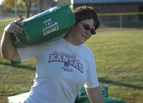 WHITEMAN AIR FORCE BASE, Mo. -  Airman 1st Class Helen Cramer, Whiteman Airmen’s Council, carries a fifty pound bag of turf to a baseball field Oct. 31. The Whiteman Airmen’s Council teamed up with Whiteman Youth Programs to put out more than 10 tons of turf onto two baseball fields. (U. S. Air Force photo/Senior Airman Stephen Linch)