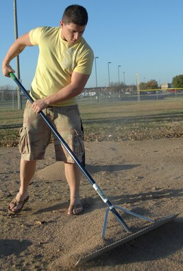 WHITEMAN AIR FORCE BASE, Mo. - Airman 1st Class Philip Singer, Whiteman Airmen’s Council, smoothes out turf on a baseball field Oct. 31. The Whiteman Airmen’s Council teamed up with Whiteman Youth Programs to put out more than 10 tons of turf onto two baseball fields. (U. S. Air Force photo/Senior Airman Stephen Linch)
