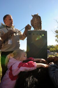 LANGLEY AIR FORCE BASE, Va.-- Terry "Rock" Moeslein from the Virginia Living Museum displays a great horned owl while Madison, age four, feels the bear skin on display at the Child Development Center Oct. 31. The skin was part of a traveling display of furs, fossils, bones and stones. (U.S. Air Force photo/Airman Rebecca Montez)