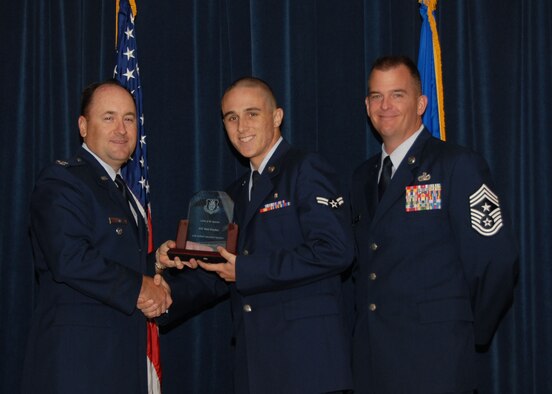 Col. Stuart Shaw, 97th Air Mobility Wing vice commander, (L), and Command Chief Master Sgt. Malloy congratulates Airman 1st Class Mark Donahue as Wing Airman of the 3rd Quarter, on Oct. 23. His outstanding accomplishments in the 97th Medical Group led to this day of recognition. (U.S. Air Force photo/Airman 1st Class Marianne E. Lane)