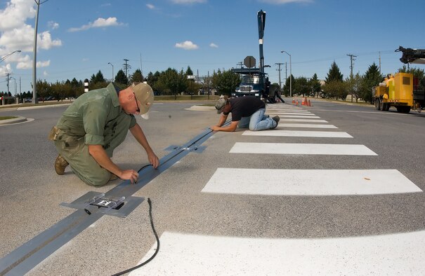 Contractors install crosswalk lights at Dover Air Force Base.  The new lights will make crosswalks safer for pedestrians.  The crosswalks were paid for using funds from the 2008 Commander in Chief's Annual Award for Installation Excellence.  (U.S. Air Force photo/Jason Minto) 