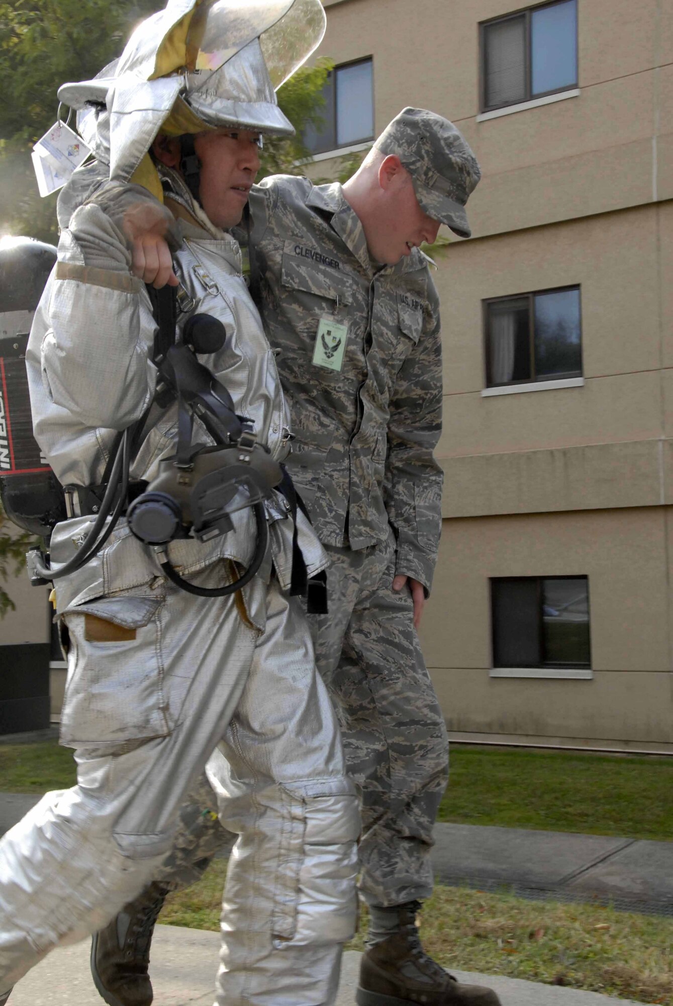 OSAN AIR BASE, Republic of Korea -- (From left to right) Sankil Pak, 51st Civil Engineer Squadron firefighter, assists Senior Airman Ryan Clevenger, 51st Aircraft Maintenance Squadron weapons loader, during a base-wide mass casualty exercise Nov. 3. The exercise tests base personnel's ability to transition from peacetime to wartime operations, execution of the mission in a war time environment, and response time to major accidents and natural disasters. (U.S. Air Force photo/Staff Sgt. Lakisha Croley)