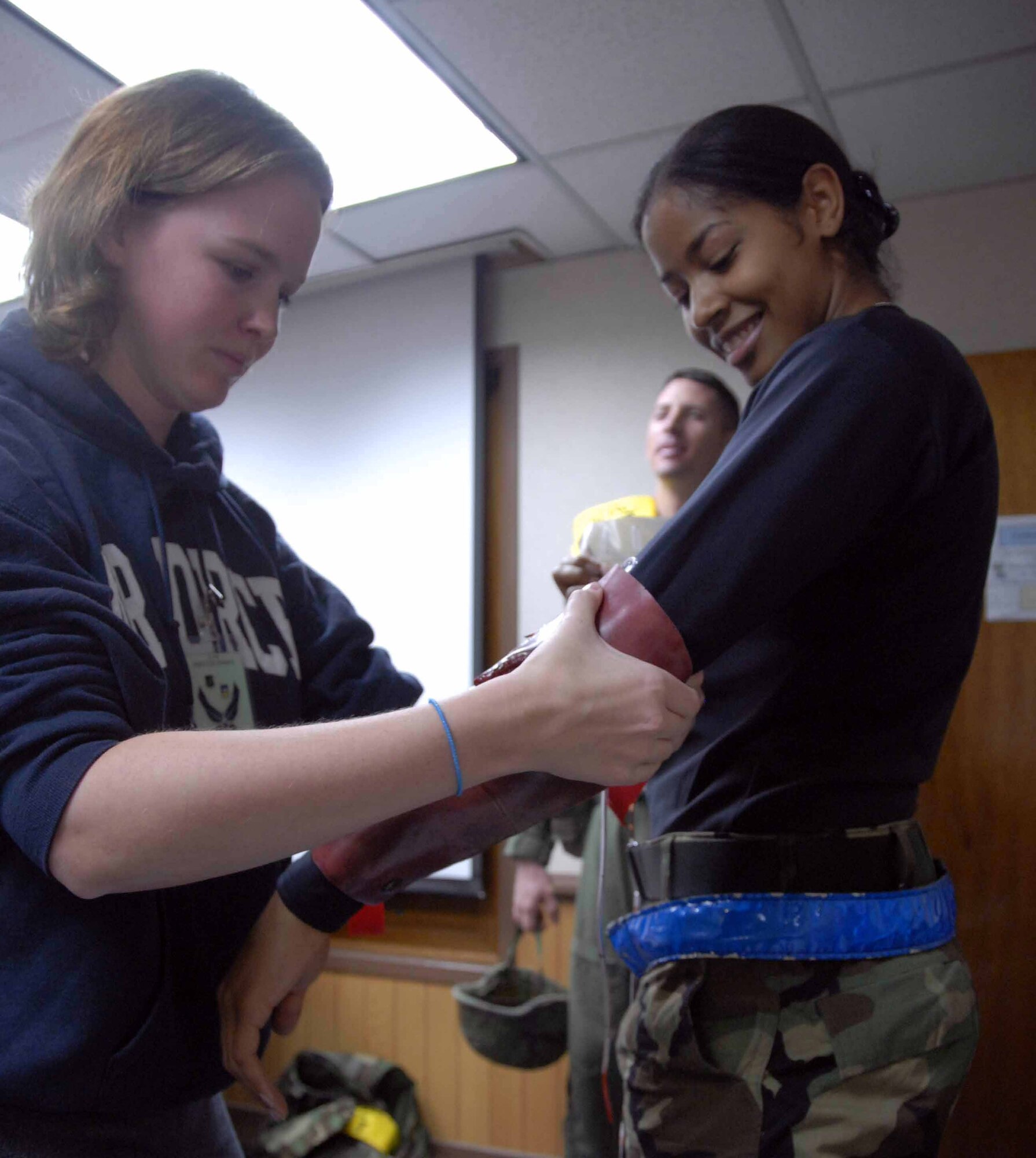 OSAN AIR BASE, Republic of Korea -- (From left to right) Erica Anderson, 51st Medical Group education and training section, prepares Senior Airman Monieka Stokes, 51st Maintenance Squadron air fuel systems apprentice, for her role as a "wounded" citizen in a mass casualty simulation during a base-wide exercise Nov. 3. The exercise tests base personnel's ability to transition from peacetime to wartime operations, execution of the mission in a war time environment, and response time to major accidents and natural disasters. (U.S. Air Force photo/Staff Sgt. Lakisha Croley)