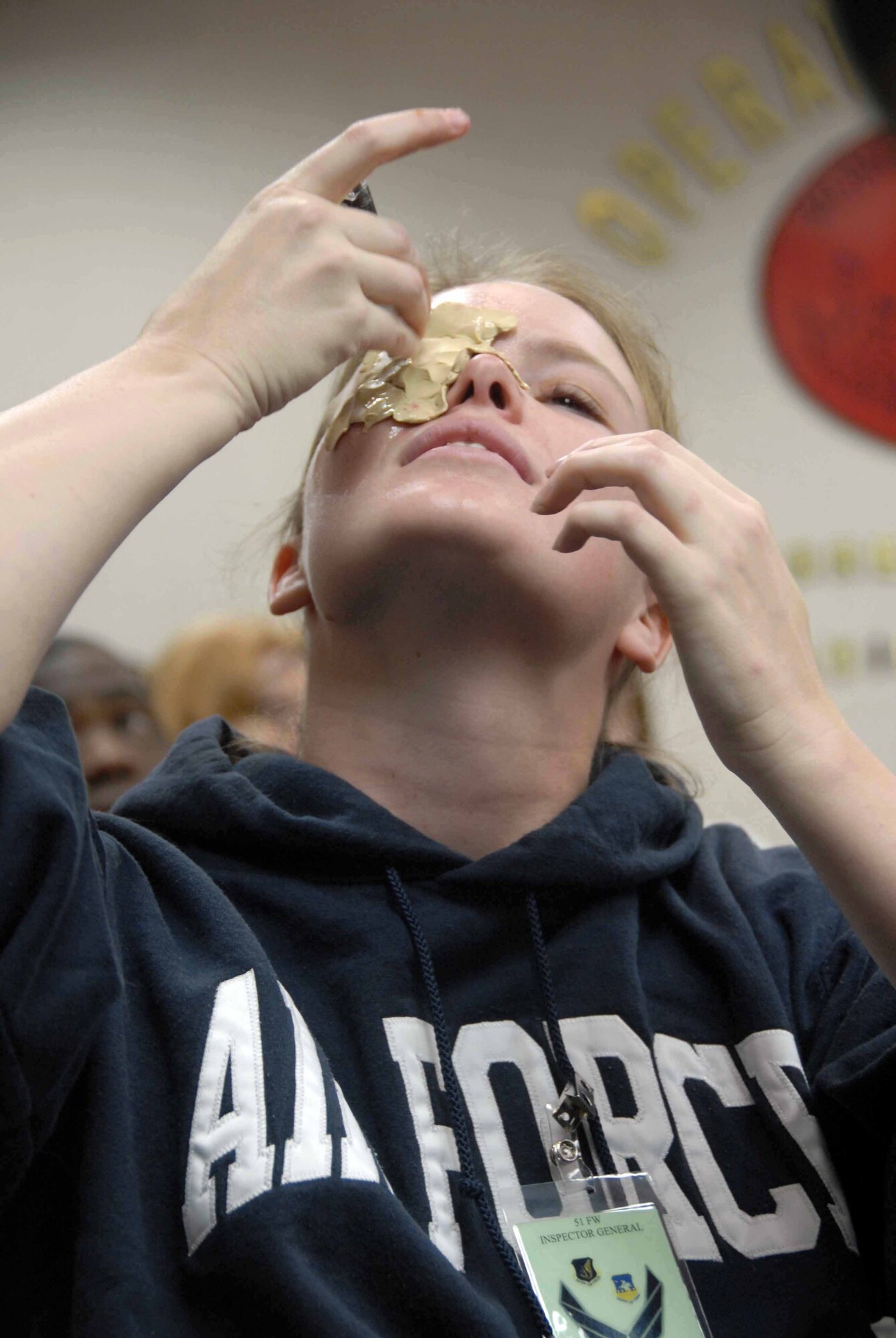 OSAN AIR BASE, Republic of Korea -- Erica Anderson, 51st Medical Group education and training section, allows the glue to dry on her "eye wound" in preparation for a mass casualty simulation during a base-wide exercise Nov. 3. The exercise tests base personnel's ability to transition from peacetime to wartime operations, execution of the mission in a war time environment, and response time to major accidents and natural disasters. (U.S. Air Force photo/Staff Sgt. Lakisha Croley)