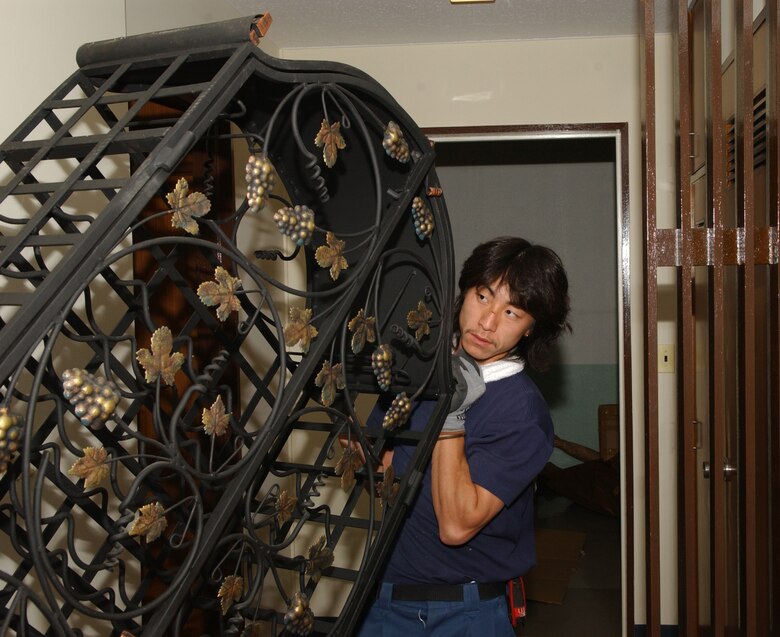 Mr. Hide Takahashi moves a wine cabinet into the Petersen's new home here Nov. 3. Senior Master Sgt. Timothy Petersen recently permently changed stations to Yokota and recieving his furniture and house hold goods from his previous station. (U.S. AIr Force photo by Airman 1st Class Eric Summers)