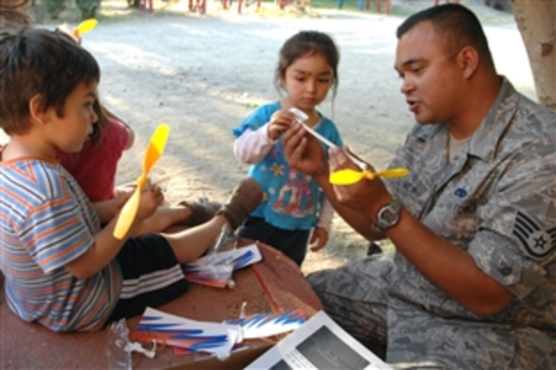 U.S. Air Force Staff Sgt. Lee Fortner demonstrates how to build a model airplane to children at an orphanage, Santiago, Chile, Oct. 30, 2008. Fortner is assigned to the 355th Maintenance Group and is one of about 70 airmen participating in Operation Southern Partner, an outreach program spanning four South American countries.