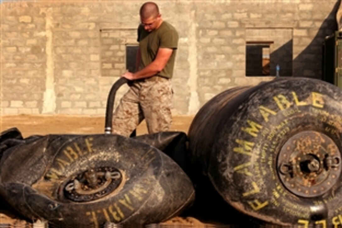 U.S. Marine Corps Lance Cpl. Scott M. Comstock fills a fuel bladder at the 26th Marine Expeditionary Unit's Forward Arming and Refueling Point, Oct. 26, 2008, in the Middle East. Comstock is a bulk fuel specialist with the Marine Medium Helicopter Squadron-264, 26th Marine Expeditionary Unit.