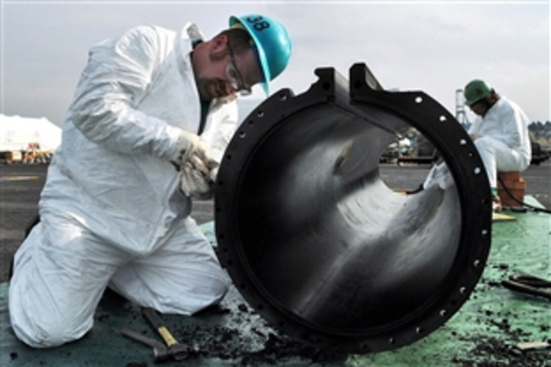 Darren Schmittler cleans a section of a steam-powered catapult track aboard the aircraft carrier USS Abraham Lincoln during maintenance at Puget Sound Naval Shipyard in Everett, Wash., Oct. 30, 2008. The ship is undergoing regular maintenance after returning from a seven-month deployment to the U.S. 5th Fleet area of responsibility.