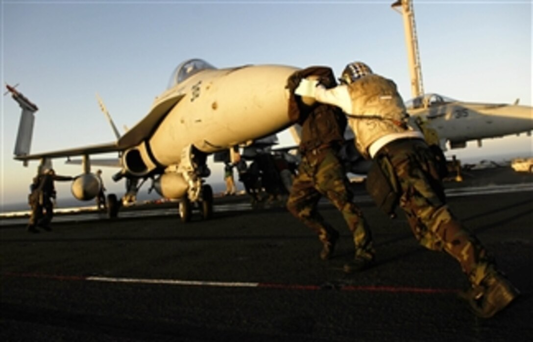 U.S. Navy sailors push an F/A-18C Hornet aircraft from Strike Fighter Squadron 146 into the corral area of the flight deck on board the aircraft carrier USS John C. Stennis (CVN 74) while underway in the Pacific Ocean on Oct. 29, 2008.  The John C. Stennis Carrier Strike Group is conducting a composite training unit exercise off the coast of southern California.  