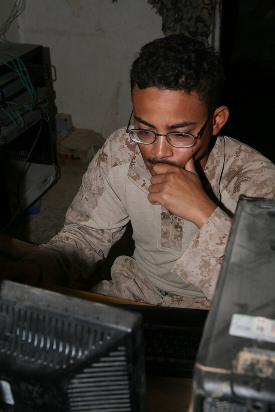 Cpl. Alex Raymundo, a data technician with Provisional Rifle Platoon 3, Regimental Combat Team 5, surfs the net between patrols at Traffic Control Point 3 in Rawah, Iraq, Nov. 1. Raymundo and the other Marines in the platoon are kept busy with missions and renovation projects around the TCP, but they also have time to keep in touch with family, a benefit that keeps the platoon's collective morale high.