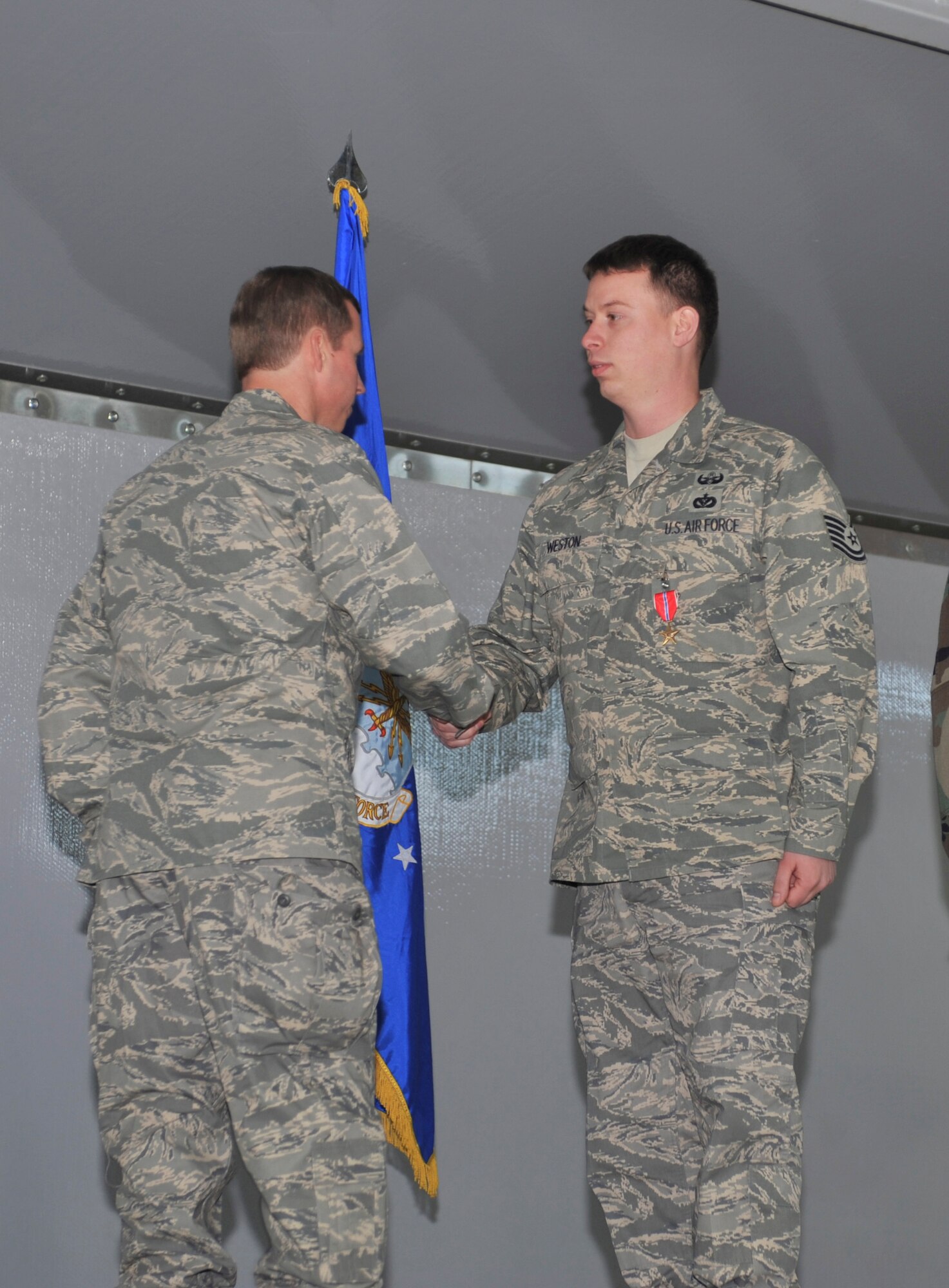 ELMENDORF AIR FORCE BASE, Alaska -- Tech. Sgt. Robert Weston shakes the hand with Col. Thomas Bergeson, 3rd Wing commander, after receiving a Bronze Star for his action during a recent deployment at the Arctic Warrior Welcome home luncheon Oct. 31. Sergeant Weston is a member of the 3rd Civil Engineer Squadron Explosive Ordnance Disposal Flight here. (U.S. Air Force photo/Senior Airman Tinese Treadwell)