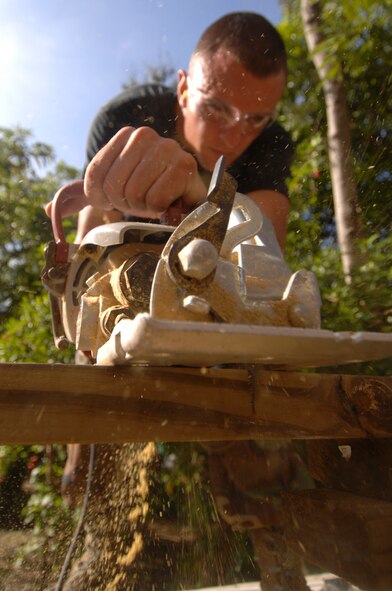 SANTO DOMINGO, Dominican Republic -- Airman 1st Class Matthew Bass, 5th Civil Engineer Squadron heating, ventilation, air conditioning apprentice, cuts wood to be used in the construction of tables and benches for one of the many construction, renovation and civil engineering projects here in support of Continuing Promise 2008. CP 2008 is a collaborative effort between the United States and partner militaries, non-governmental organizations, and partner-nation support organizations to build strong partnerships that can be called upon in the event of a regional situation requiring cooperative solutions. (U.S. Navy photo by Mass Communication Specialist Seaman Ernest Scott)