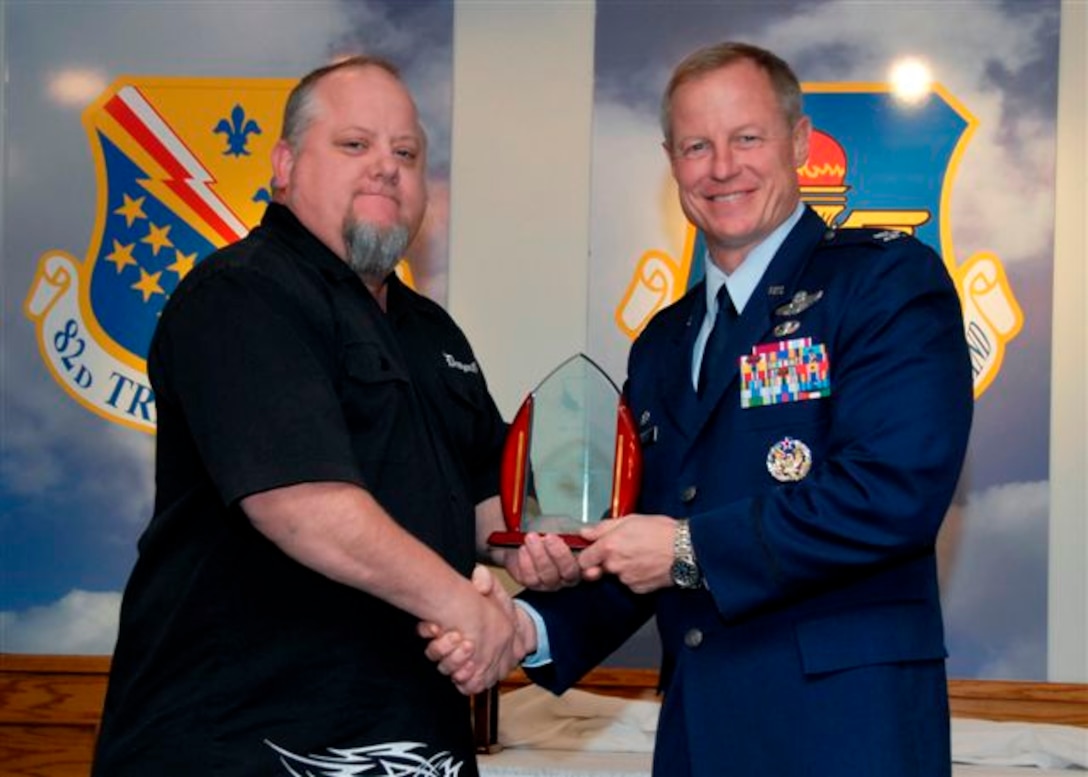 Col. David Petersen, 80th Flying Training Wing commander, presents Brian Seigars, 80th Operations Support Squadron, with the Category III Civilian of the Quarter award at the wing quarterly awards ceremony Oct. 21. (U.S. Air Force photo)